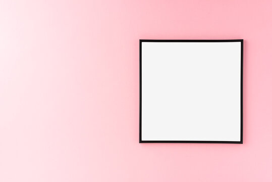 Empty picture frame on pink wall. Mockup with copyspace