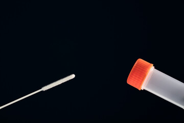 Analysis test to detect SARS-CoV-2 RNA by PCR, swab, transparent vial with data sticker and orange closure.Blue background.