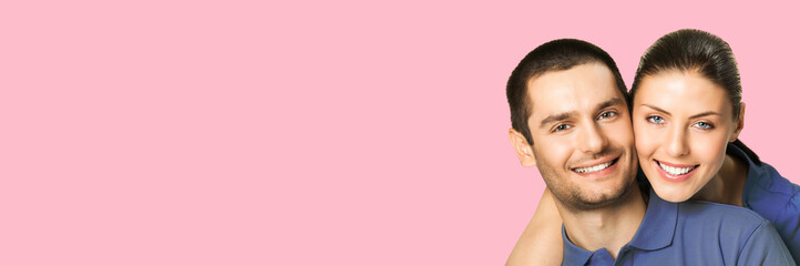 Love, relationship, lovers concept - studio portrait image of happy smiling embracing couple, man and woman in piggyback pose, isolate over pink color background. Copy space for text.