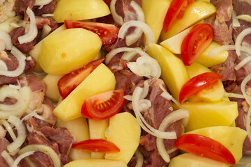 pork meat, potatoes, tomatoes and onions, ready to bake
