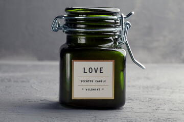 KIEV, UKRAINE - DECEMBER 11, 2020: Small scented candle in a green glass candlestick with a tight lid. Paraffin and vegetable wax