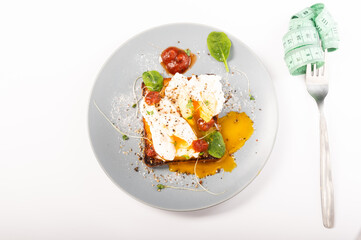 Poached eggs and a fork with a ruler. Dietary food.