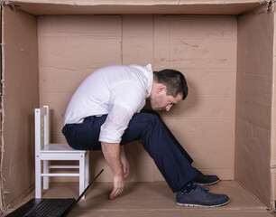 broken businessman in a cardboard office, stress and depression from overwork