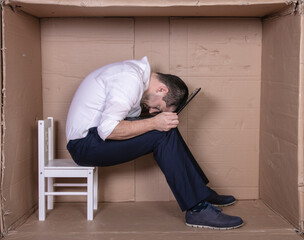 broken businessman in a cardboard office, stress and depression from overwork