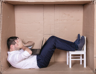 broken businessman in a cardboard office, stress and depression from overwork