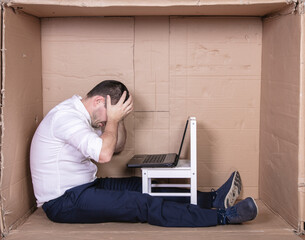broken businessman in a cardboard office, stress and depression from overwork