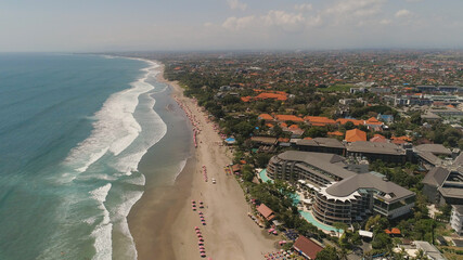 Aerial view sand beach with resting people, hotels and tourists, sun umbrellas, Bali, Kuta. surfers on water surface. Seascape, beach, ocean, sky sea Travel concept