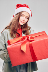 girl with a Christmas gift in a box New year gray background headdress 