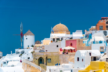 Stunning, amazing and beautiful classic white and caramel color Greek architecture with unbelievable wind mills on Santorini volcano Cyclades Caldera island,  Aegean sea in Greece.