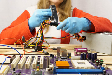 A woman winds electrical tape around the wires.