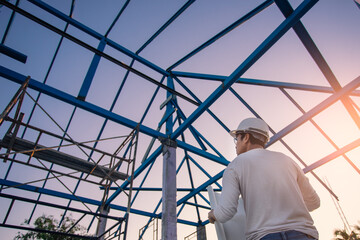 Asian man architect project house construction. Professional engineer wearing helmet and holding...