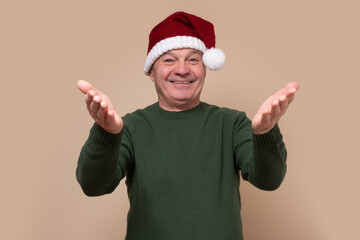 Fototapeta na wymiar Handsome senior man with christmas hat looking at the camera smiling with open arms for hug. Happy new year concept.