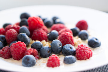 Naklejka premium Tasty oatmeal with berries for breakfast, close-up, top view, horizontal