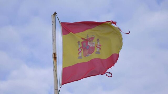 Damaged spanish flag waving in the wind in slow motion 180fps