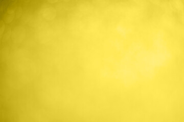 An abstract christmas bokeh blurred yellow illuminating lights background. Color 2021. Selective focus.