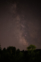 summer night sky with milky way galaxy shining trough stars and planets