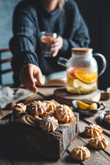 A woman reaches for a cake and drinks grapefruit tea. Healthy 