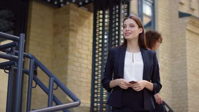 Lady taking order from courier outdoors. Business woman paying delivery man card