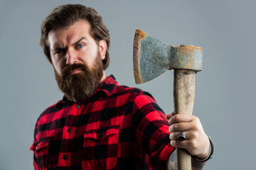 woodcutter in a plaid shirt. Lumberjack brutal bearded man in red checkered shirt. concept of shaving. halloween. man holds an ax in his hand. bearded lumberjack with an axe. selective focus
