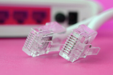 Internet router and Internet cable plugs lie on a bright pink background. Items required for...