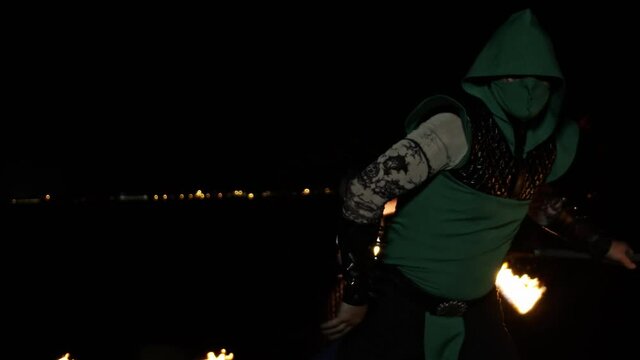 Medium shot of a male professional fire artist juggling with fire