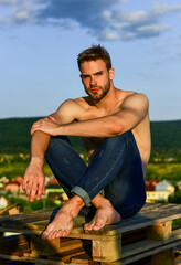 Summer lookbook. Muscular bare torso. Six packs muscular chest. Man outdoors blue sky background. Male beauty concept. Athletic handsome macho wear denim pants. Muscular body. Fitness model