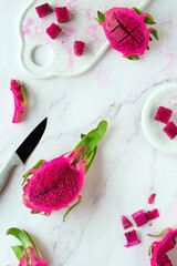 Ugly food. Juicy pink dragon fruit, pitaya, pitahaya sliced on marble table. Trendy top view with...