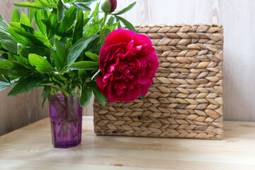 pink red peonies in wicker basket on wooden background