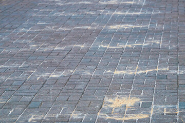 Sand and salt mixture on sidewalk in winter season spreading for melting ice and snow, prevention of slipperry on roads. Sprinkled sand and de-icing reagents on paving slab to avoid slippery