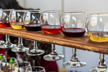 Red, rose and white wine in glasses. Tasting of various varieties, colors and shades of wine. Set of transparent wine glasses. Blurred background.