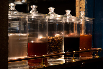 Jars with different toppings for crepes at cafe window. Parisian foodie indulgence nightlife.