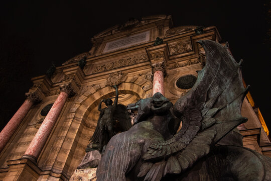 Night Fight. Saint-Michel fountain at Paris, France. Dragon and Archangel Michael at background slaying the devil.