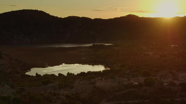 Dalyan,Mugla.Turkey.
Aerial view of Kaunos ancient city at sunset. delta and the mountains around. lence flare. 4k.