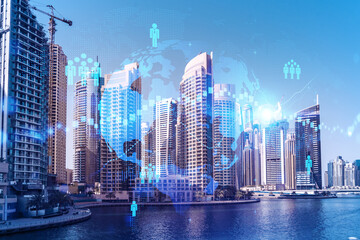 Skyscrapers of Dubai business downtown. International hub of trading and financial services. Social network icons hologram, concept of human resources. Double exposure. Dubai Canal waterfront.