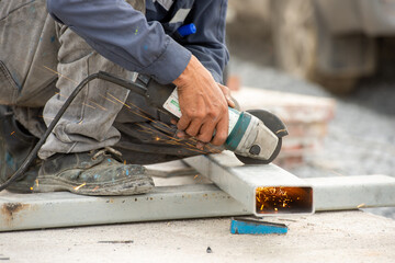 Man polishes metal with a grinding machine