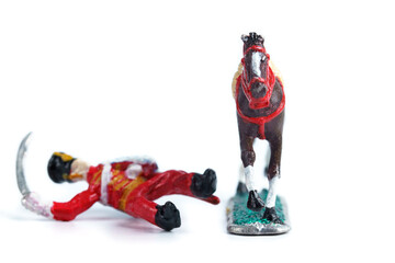 Image of handmade tin soldier fell from horse on the white background