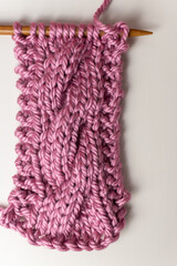 super chunky cable knitting on needle with pink yarn 