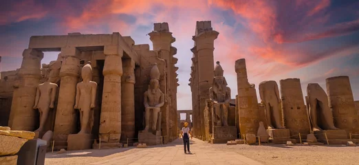 Foto op Plexiglas Sculptures of ancient Egyptian pharaohs and drawings on the columns of the Luxor Temple in the evening. Egypt © unai