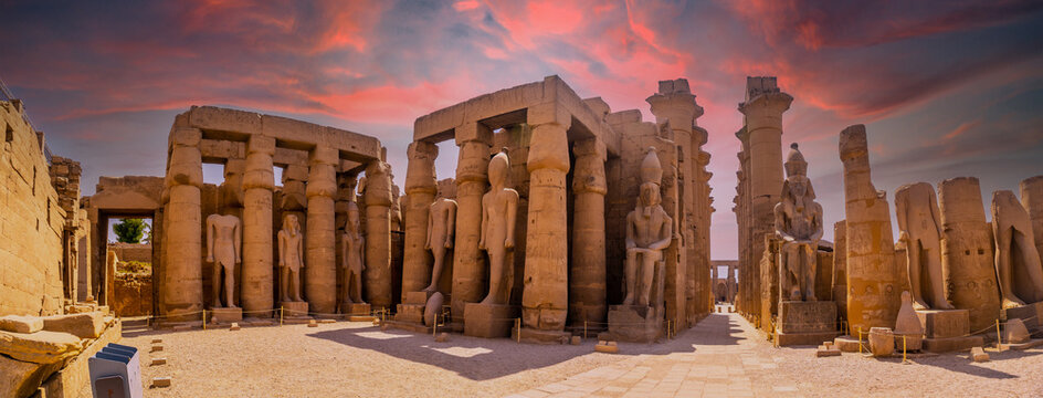 Sculptures of ancient Egyptian pharaohs and drawings on the columns of the Luxor Temple in the evening. Egypt