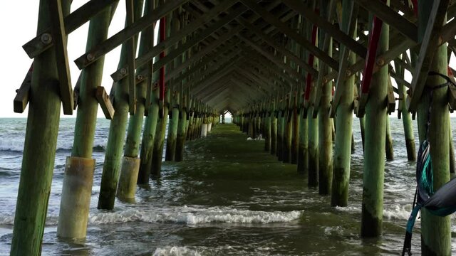 A hammock waves in the breeze under the pier at Folly Beach, South Carolina.