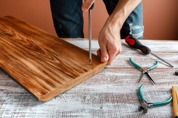 The carpenter works with wood on his workspace
