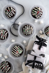 Hot Chocolate bombs on white marble background. Black and white holiday theme. 