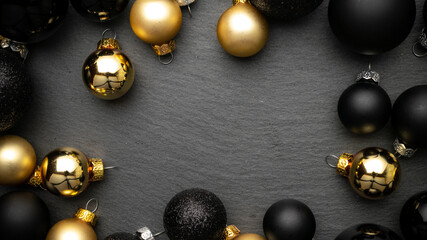 2021 Golden New Year balls, black baubles in xmas composition on dark textured background for greeting card. Copy space. Winter holidays, New Year.