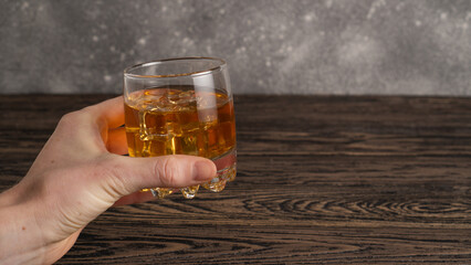 Glass of brown rum in hand. Hand hold mug of bourbon. Glass of scotch whiskey and ice