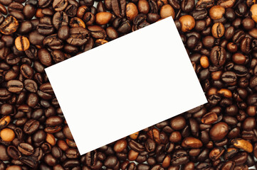 Coffee beans are scattered over the surface on a blank white background. a handful of brown coffee beans. Coffee background with copy space for inscription, text or logo rectangle. Mock up.