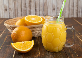 Orange juice with sliced orange over a wooden table