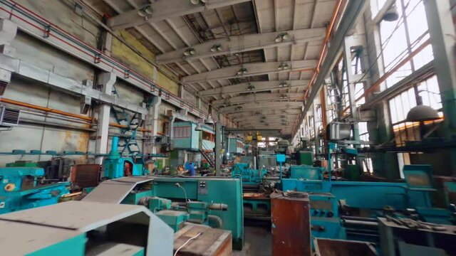 Aerial view flying low, over machinery an old car manufactory hall - FPV, drone shot