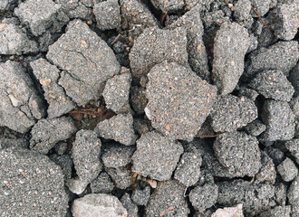 Texture, background of the destroyed, old, cracked in pieces of gray asphalt. Road works, earthquake underground.