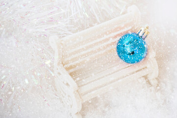 Christmas composition. New year ball on the white bench, snowflakes background. New year decorations