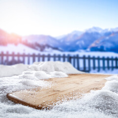 Fresh snow on a wooden table with an alpine view of the mountains